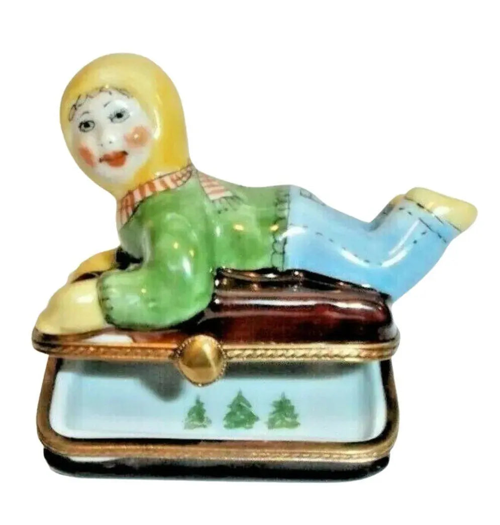 Looking inside the Kid on Sled Winter Sleigh Christmas Trees Limoges box, with its hinged lid open